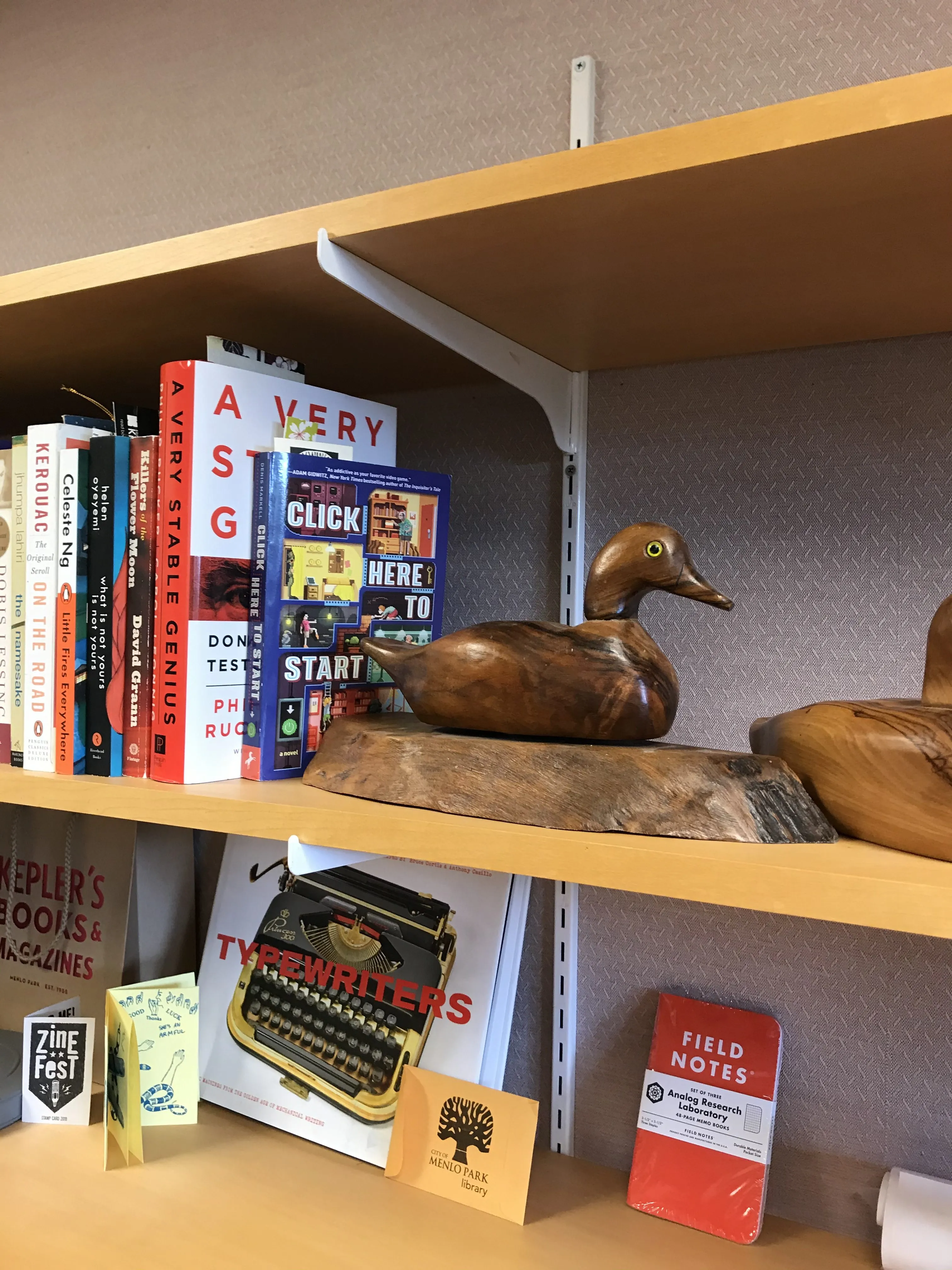 office shelf with books and wooden ducks